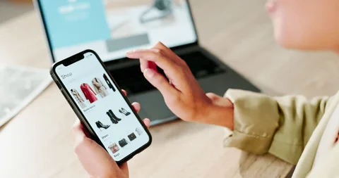 A person shopping for winter jackets on a laptop, highlighting online shopping for winter clothing deals.
