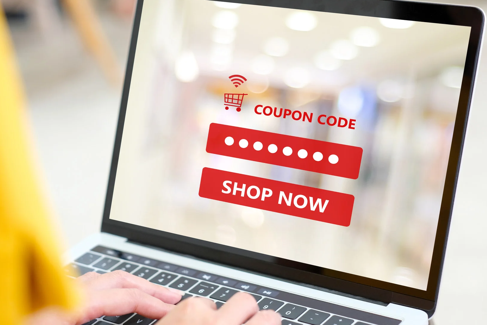 Hand typing in a coupon code to save money during online shopping