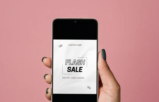 A vibrant image of a person excitedly looking at their phone, perhaps with a "flash sale" notification on the screen.